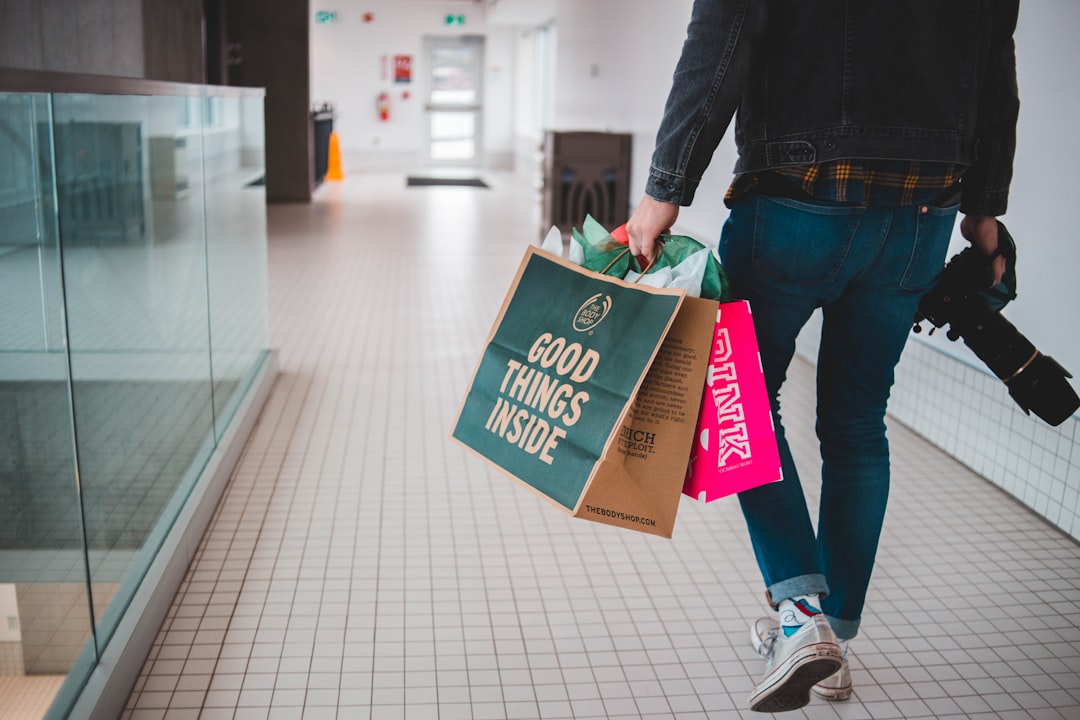 person-walking-while-carrying-a-camera-and-paper-bags-nfora6nhtbu